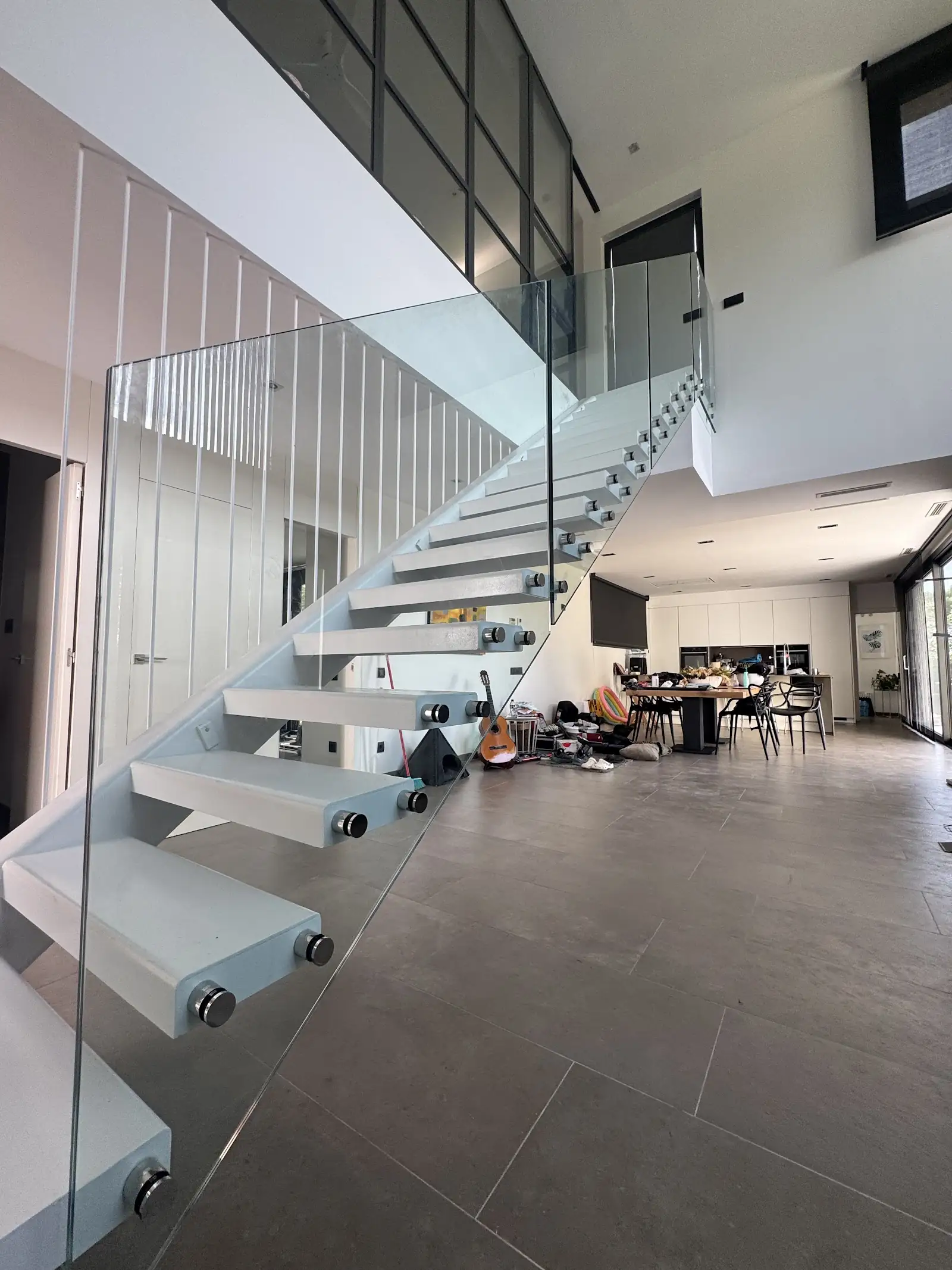 Escalera volada con barandilla de vidrio en un loft