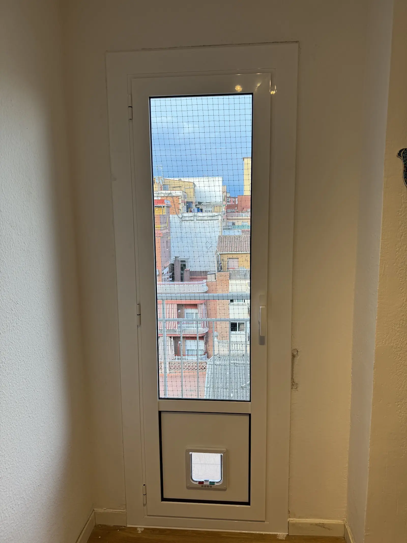 Puerta de aluminio acristalada con gatera integrada