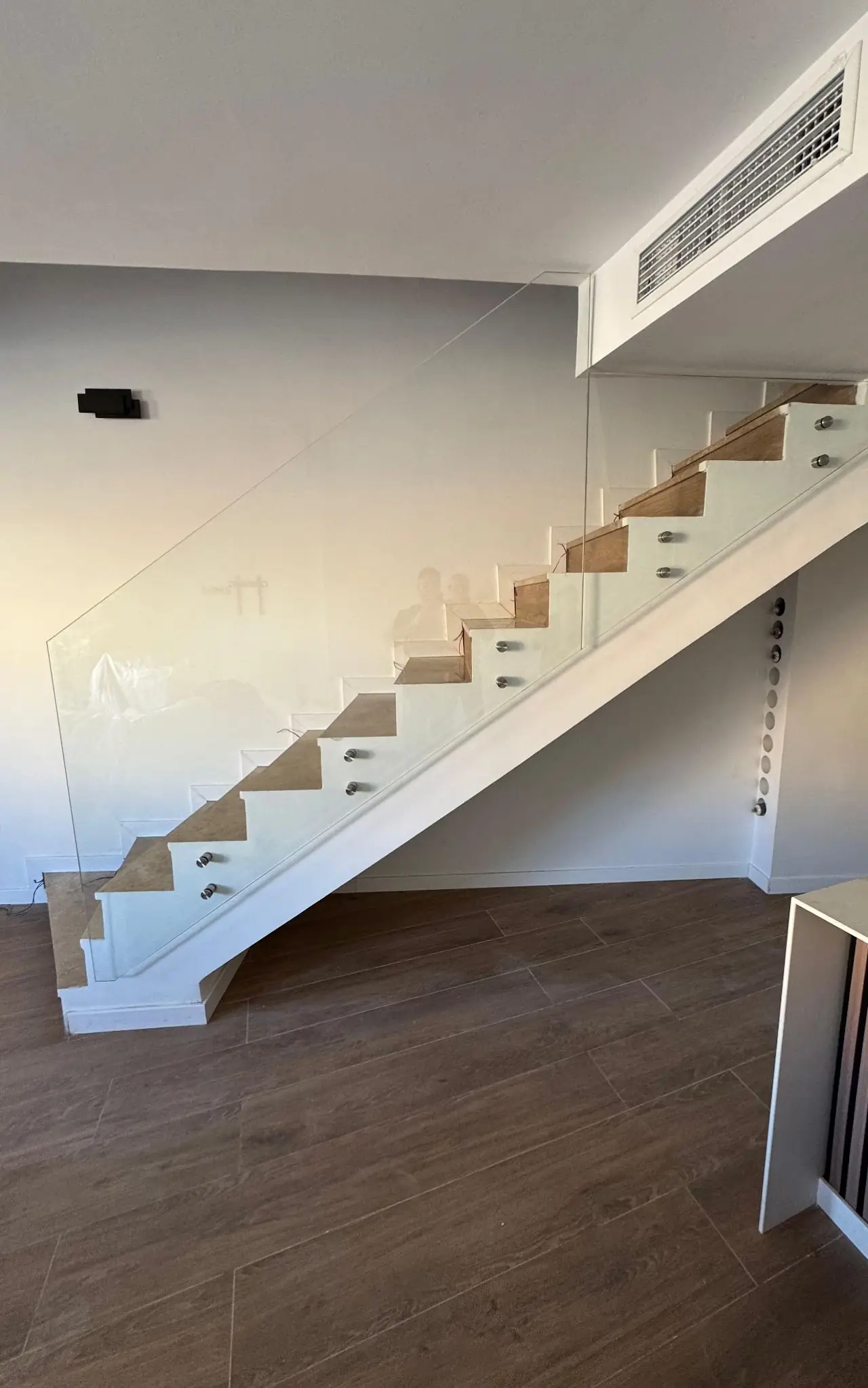 Barandilla de vidrio sin pasamanos en una escalera interior