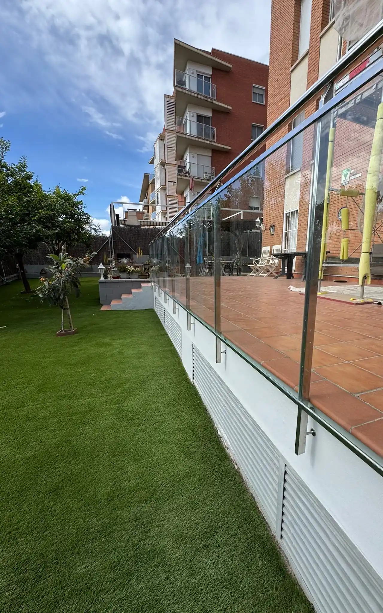 Barandilla de vidrio en una terraza junto al jardín